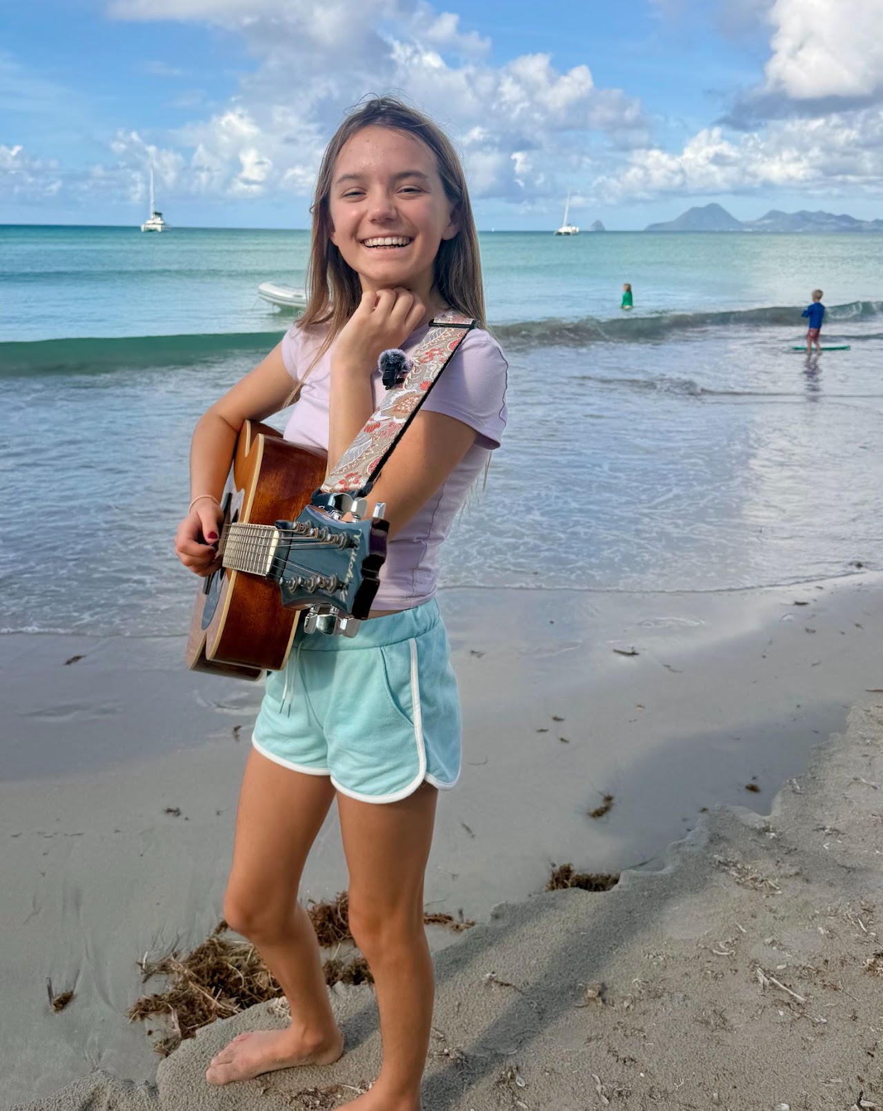 Sage Sedivec playing guitar on the beach