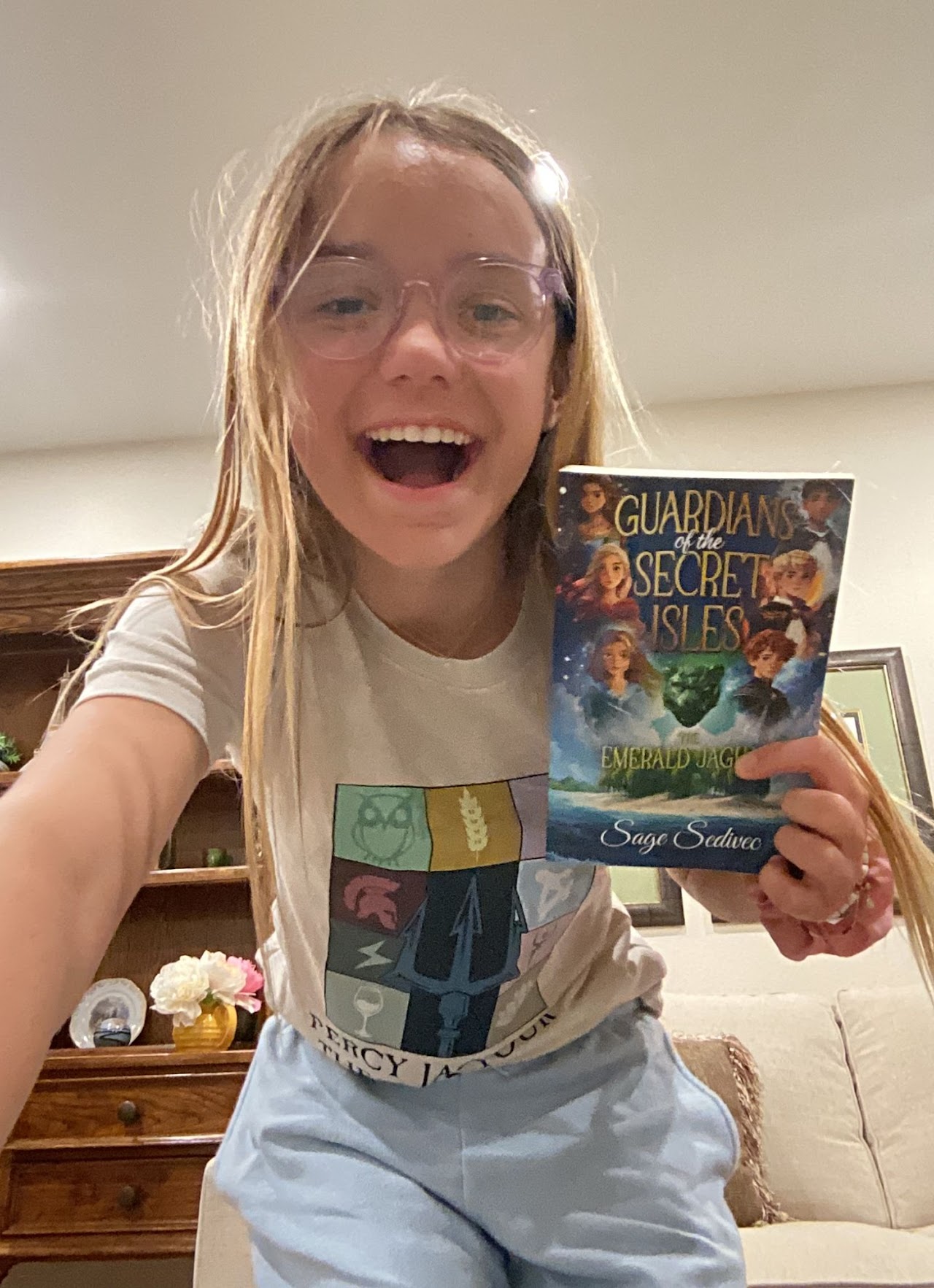 Sage holding her book Guardians of the Secret Isles